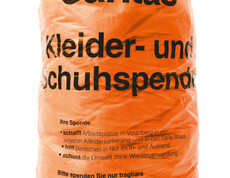 Der orange Caritas Kleidersack. Er hat Platz für zirka 8,5 Kilogramm Kleidung.