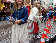 Kinder in Tracht gehen durch die feldkircher Innenstadt anlässlich des carla Reuse Days. 