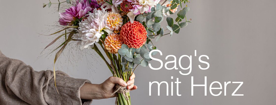 Eine Hand überreicht einen Blumenstrauß zum Muttertag