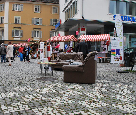 carla stellt wieder Instandgesetzte Möbel in der feldkircher Innenstadt aus. Zwei Roll-ups und eine schwarze Couch stehen am Sparkassenplatz. 
