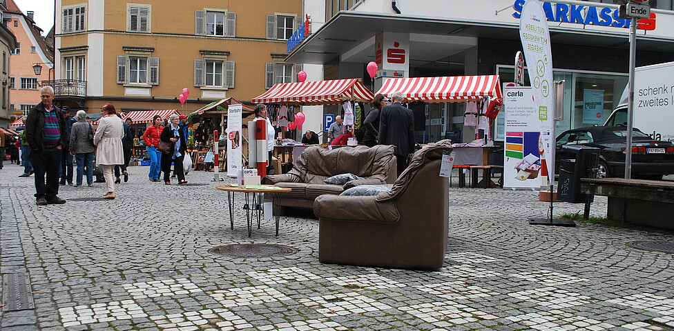 carla stellt wieder Instandgesetzte Möbel in der feldkircher Innenstadt aus. Zwei Roll-ups und eine schwarze Couch stehen am Sparkassenplatz. 
